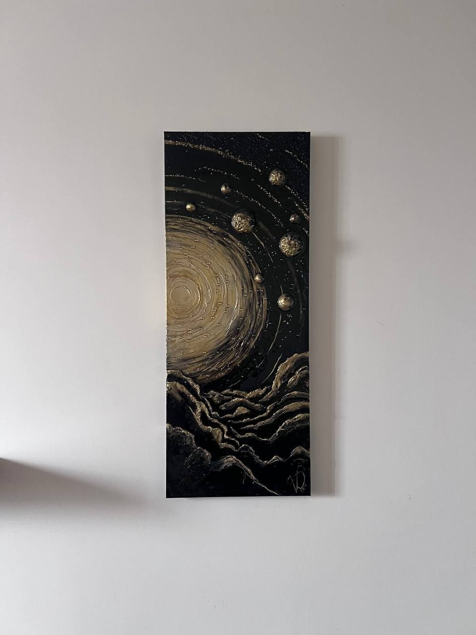 INFINITY, 40×100 cm — A glowing sun at the centre, concentric textured rings around it, gold planets standing out from the dark surface.