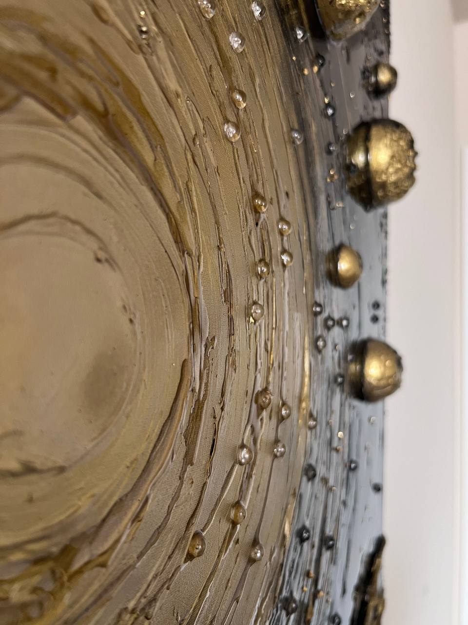 INFINITY, 40×100 cm — A glowing sun at the centre, concentric textured rings around it, gold planets standing out from the dark surface.