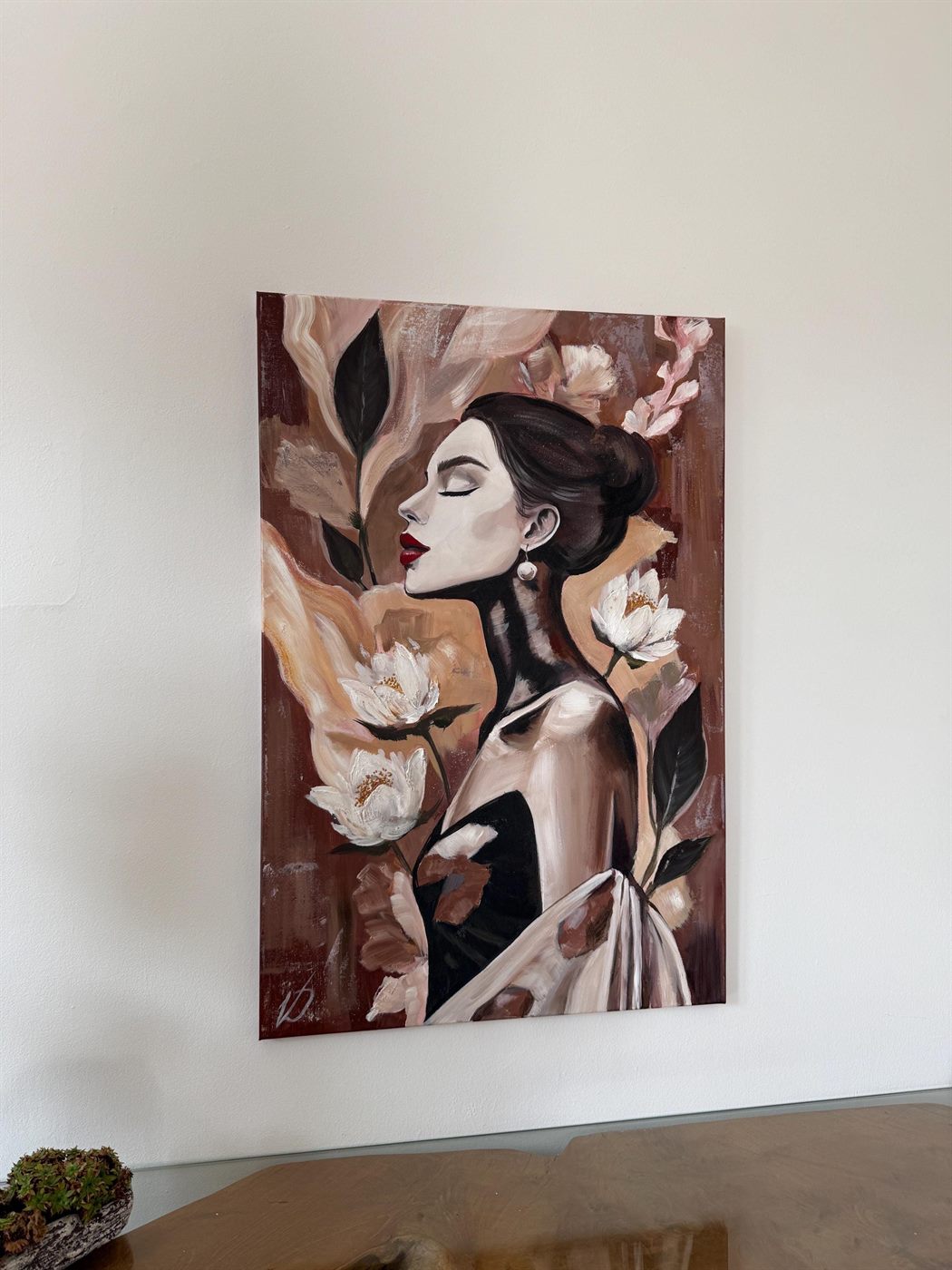 mirada, 60×80 cm — A woman in profile among magnolias, warm terracotta and rose over a dark ground.
